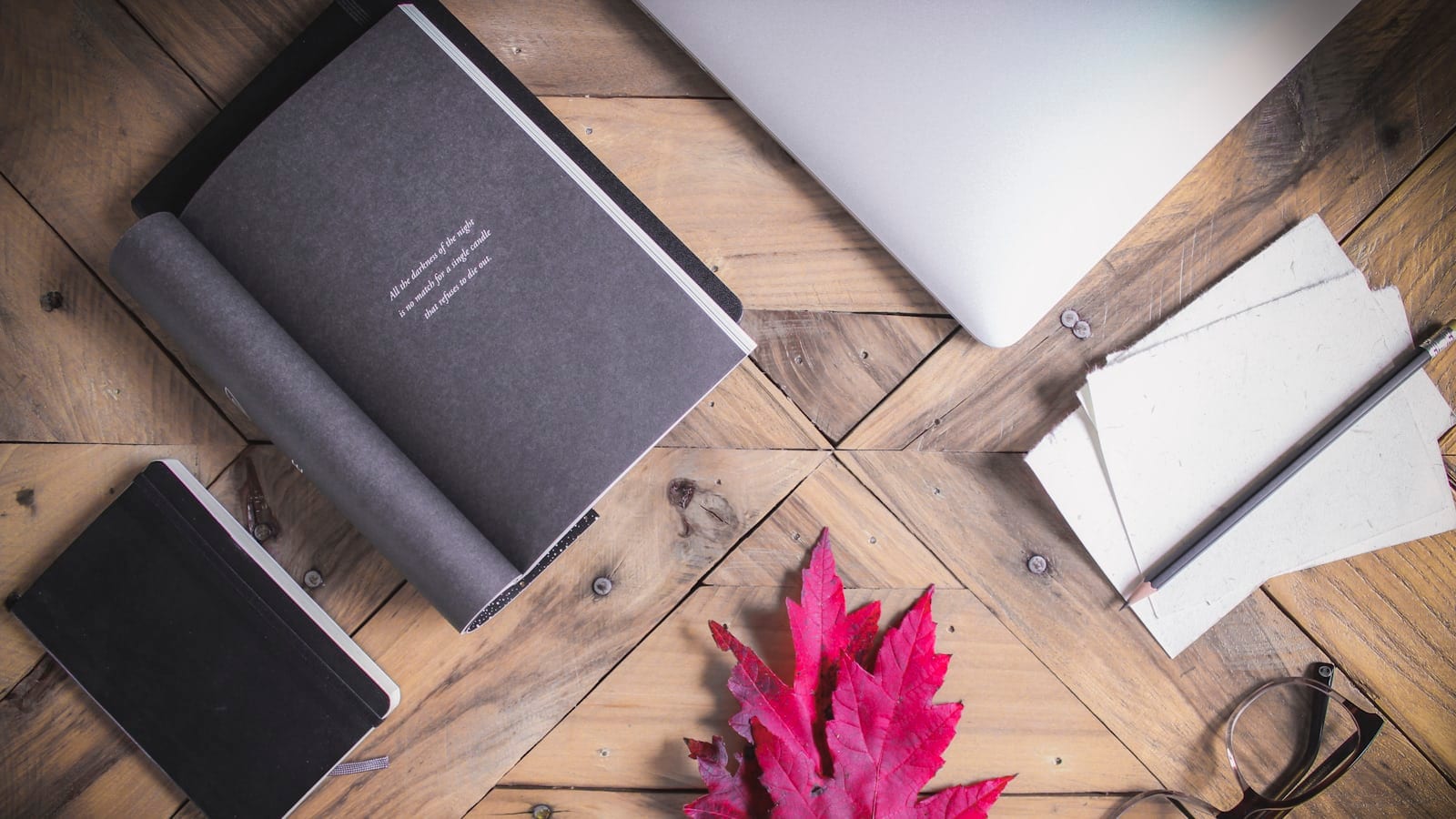 Carnets, lunettes et feuille d'érable sur un bureau en bois, ambiance rentrée